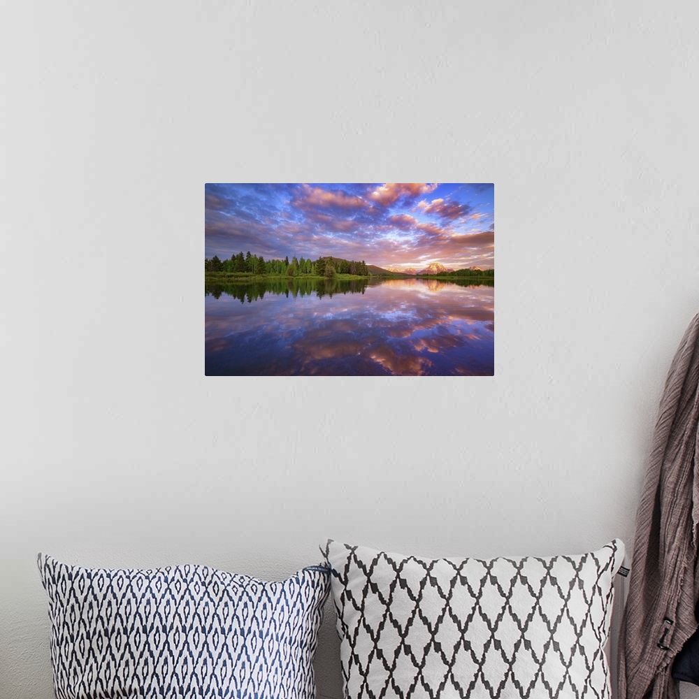 A bohemian room featuring Vibrant clouds over a lake at dawn.
