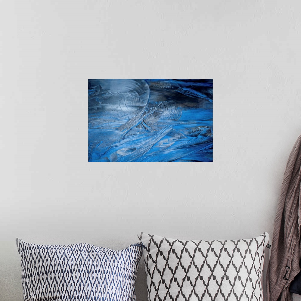 A bohemian room featuring Close-up abstract photograph of the texture from frozen water in shades of blue.