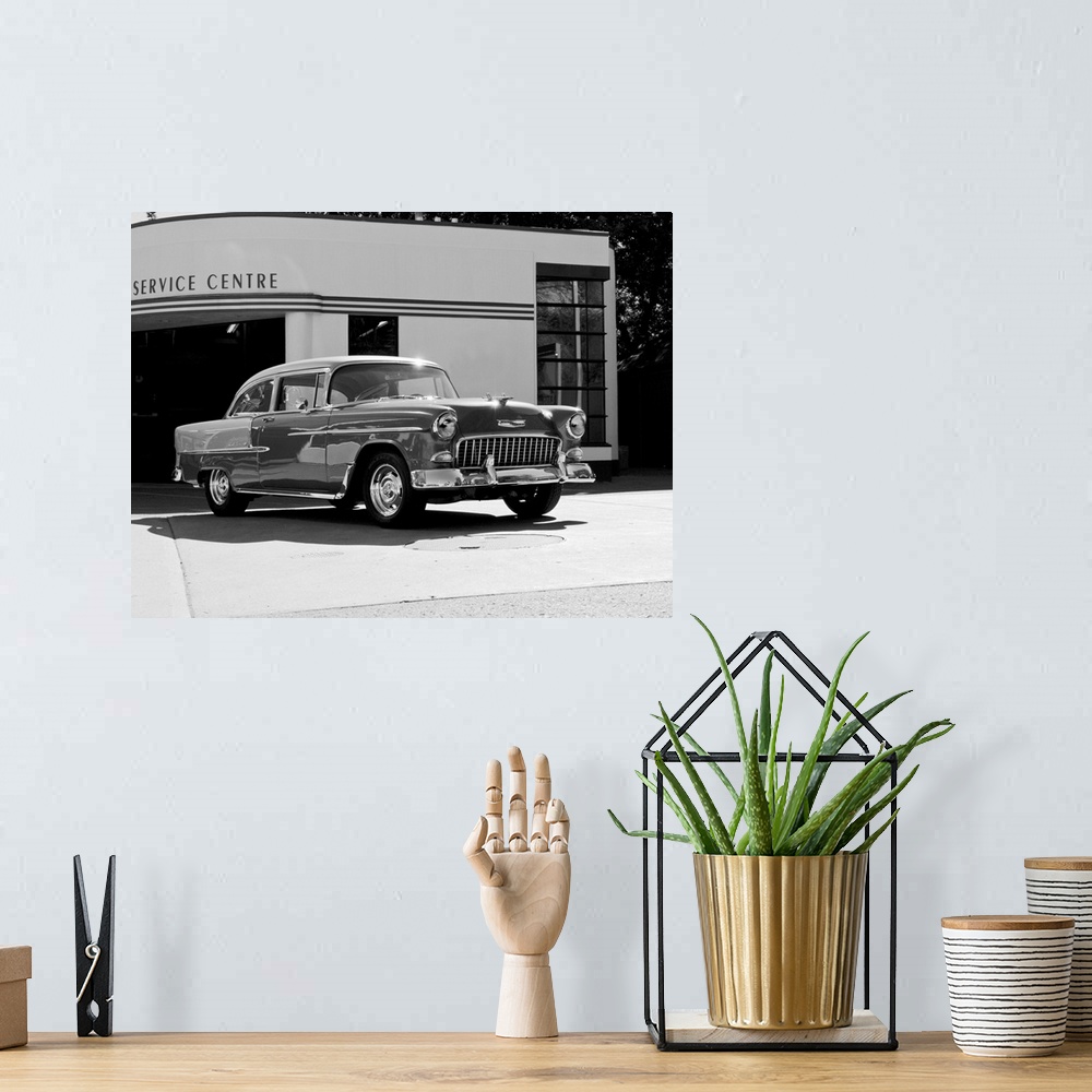 A bohemian room featuring Black and white photograph of a 1955 Chev Belair 7 in front of a service center.
