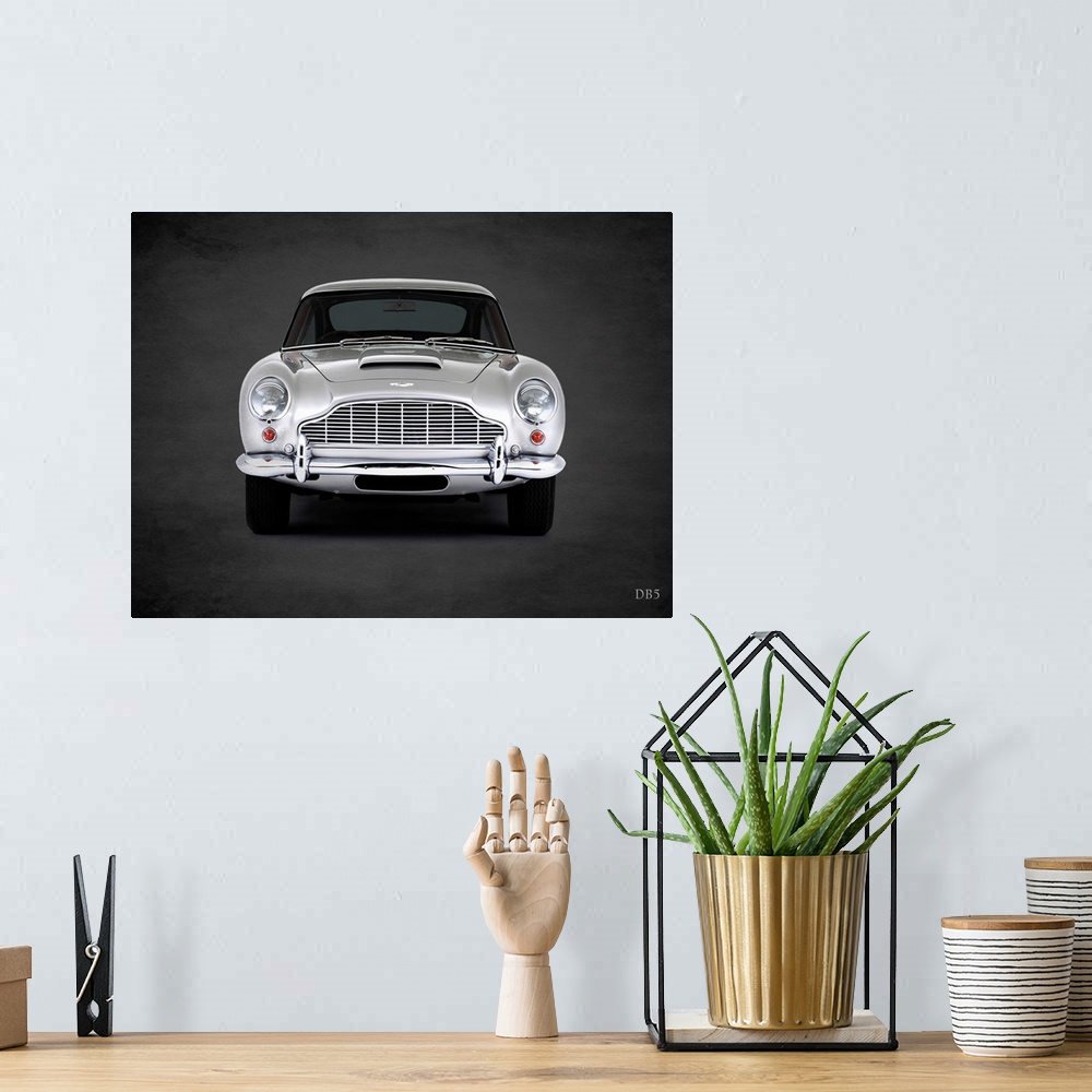 A bohemian room featuring Photograph of a silver 1965 Aston Martin DB5 printed on a black background with a dark vignette.