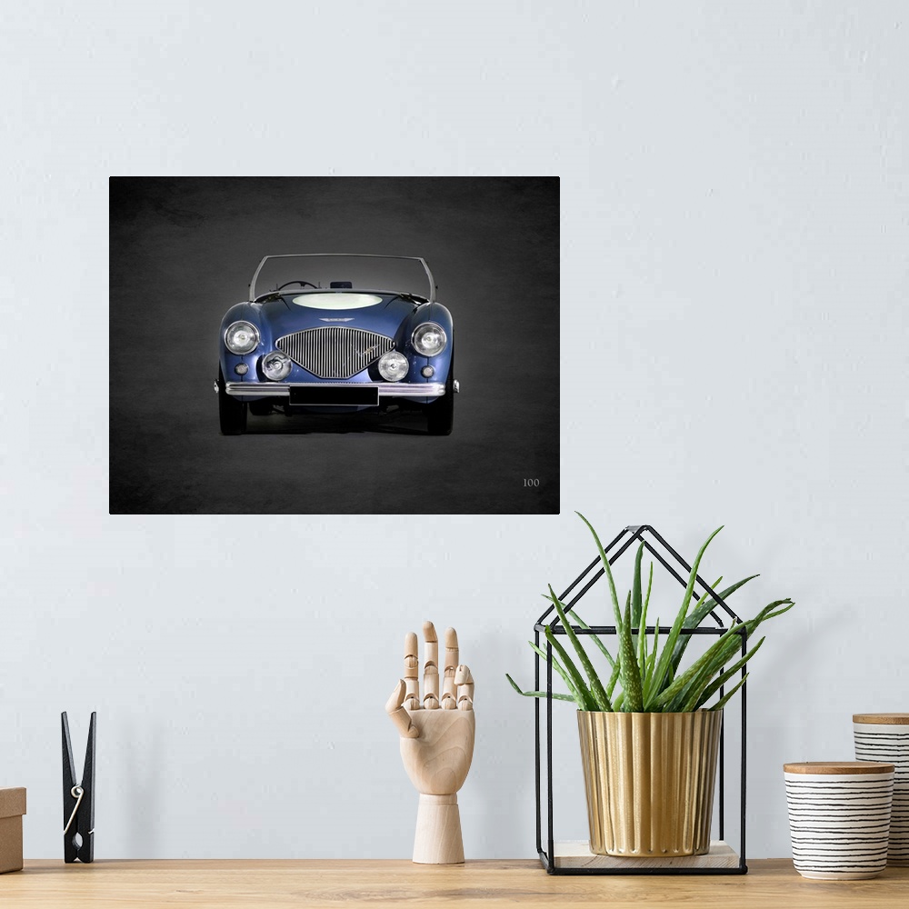 A bohemian room featuring Photograph of a blue 1953 Austin-Healey 100 printed on a black background with a dark vignette.