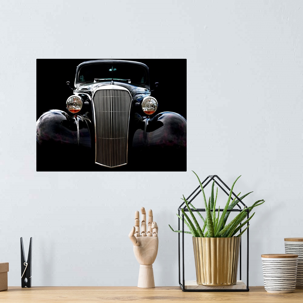 A bohemian room featuring Photograph of the front of a black vintage Chevrolet with a solid black background.