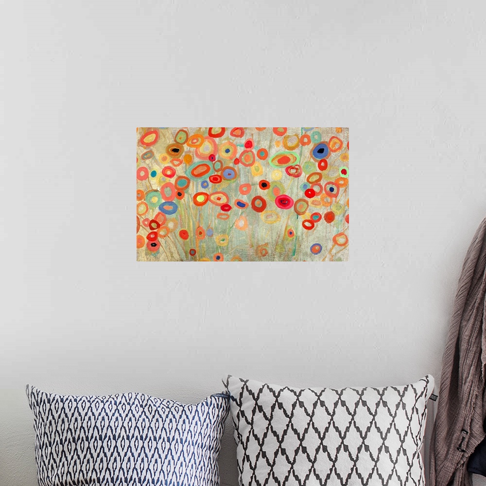 A bohemian room featuring Horizontal painting of a group of multi-colored circles against a neutral backdrop.
