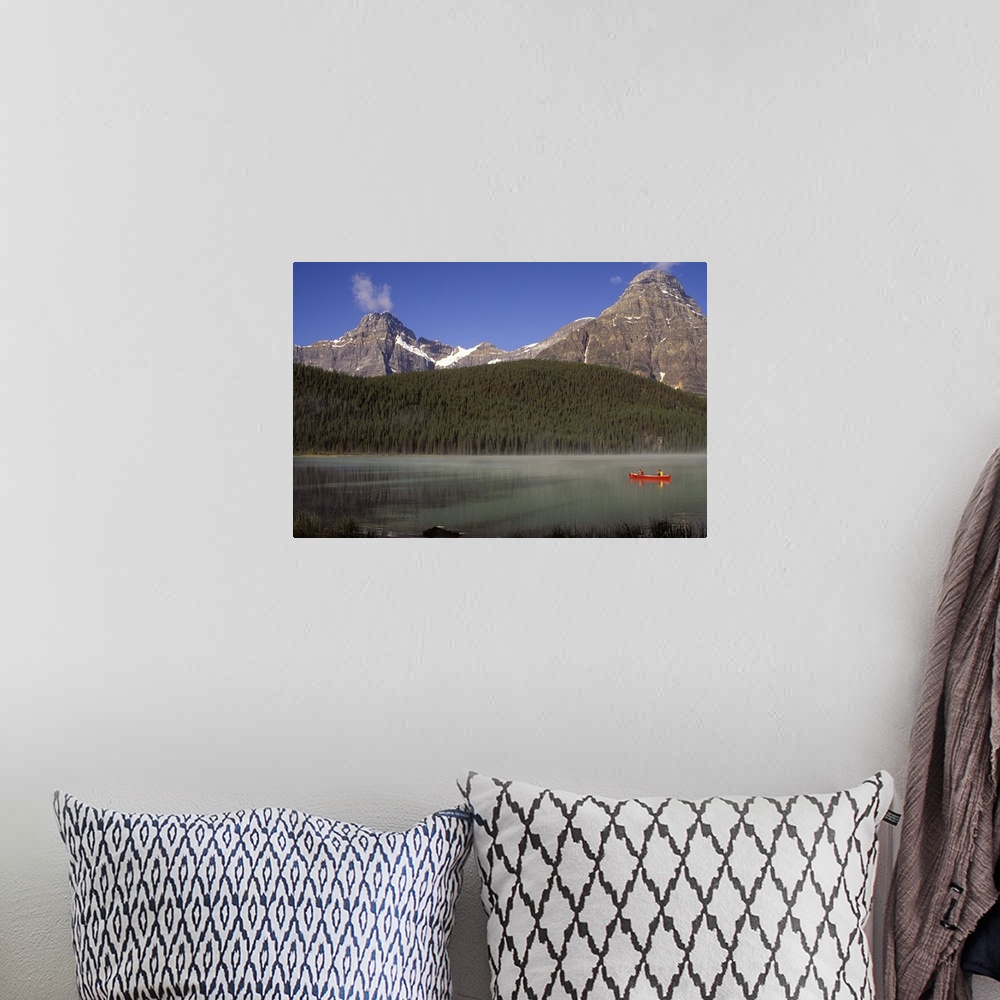 A bohemian room featuring Two boys fishing from a red canoe in Waterfowl Lake, in Canada's Banff national park.