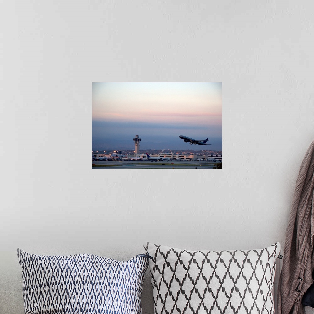 A bohemian room featuring Boeing 767 airplane taking off at LAX airport, Los Angeles, California at dusk.
