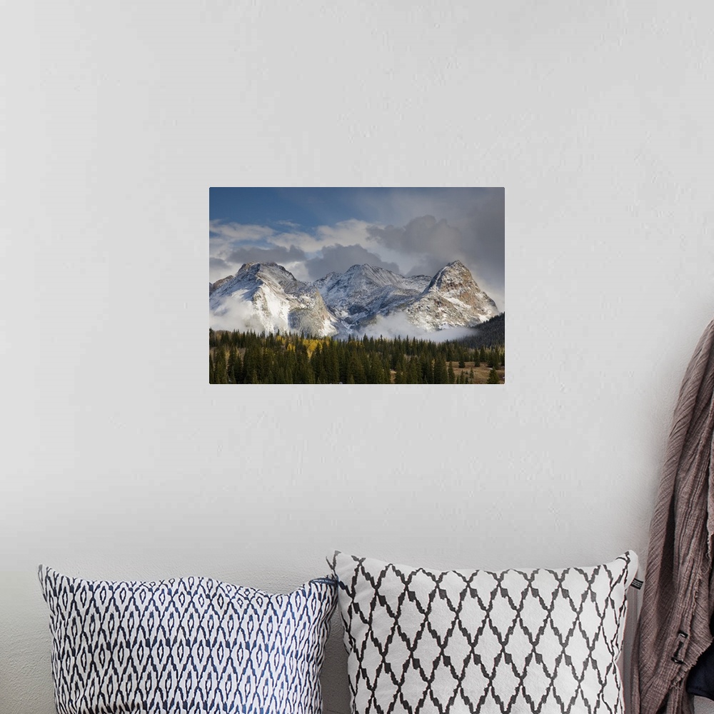 A bohemian room featuring USA, Colorado, San Juan Mountains, Uncompahgre National Forest. Clouds swirl around the snow-cove...