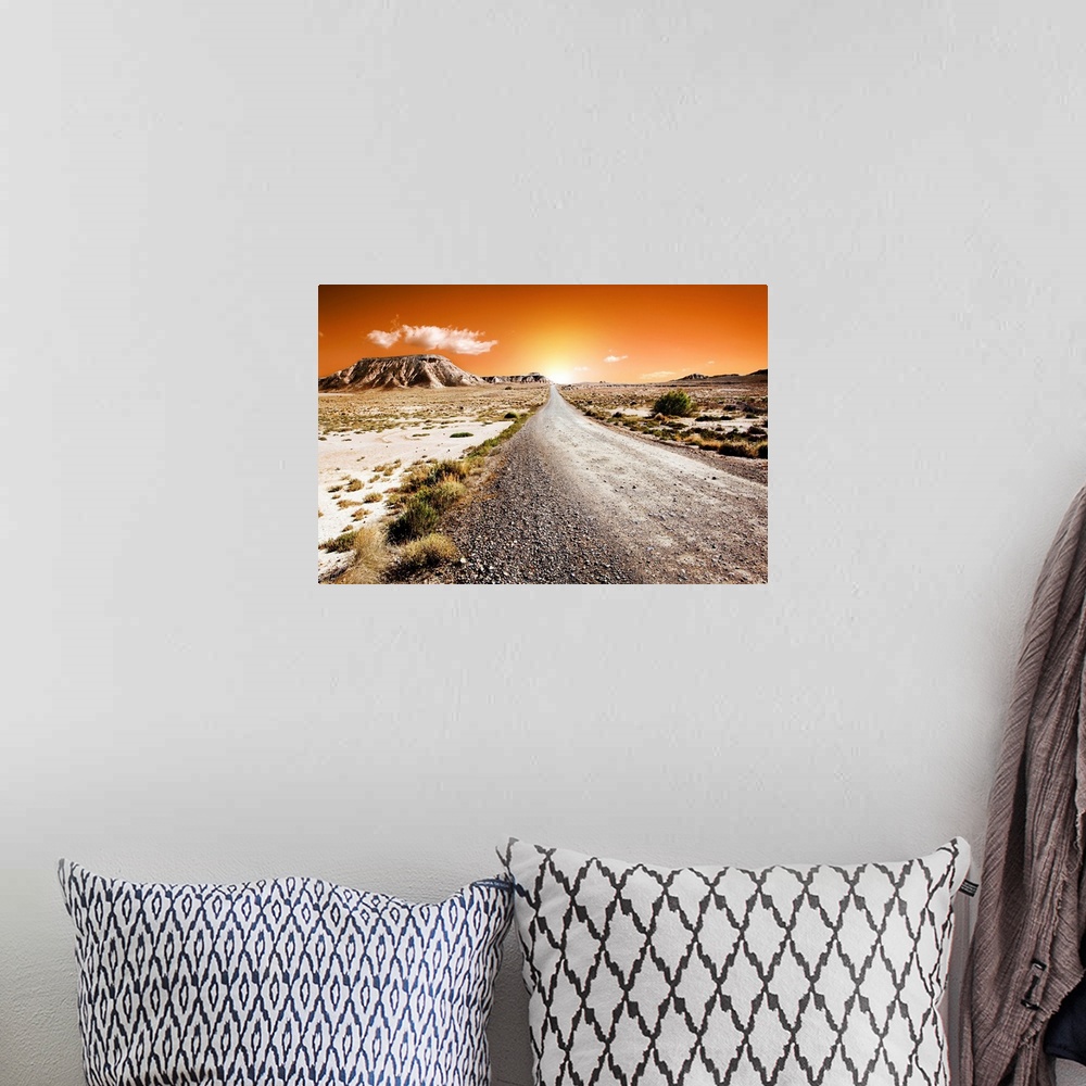 A bohemian room featuring Sunset desert landscape with road.