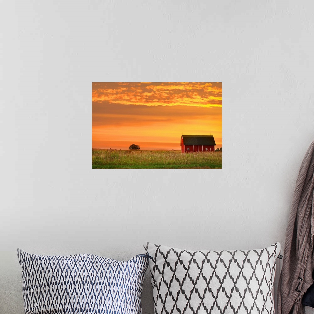 A bohemian room featuring Farm landscape with old barn against bright evening sky.