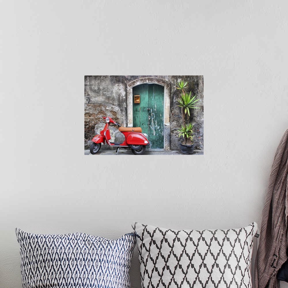 A bohemian room featuring Photo of red scooter near green door and palm.