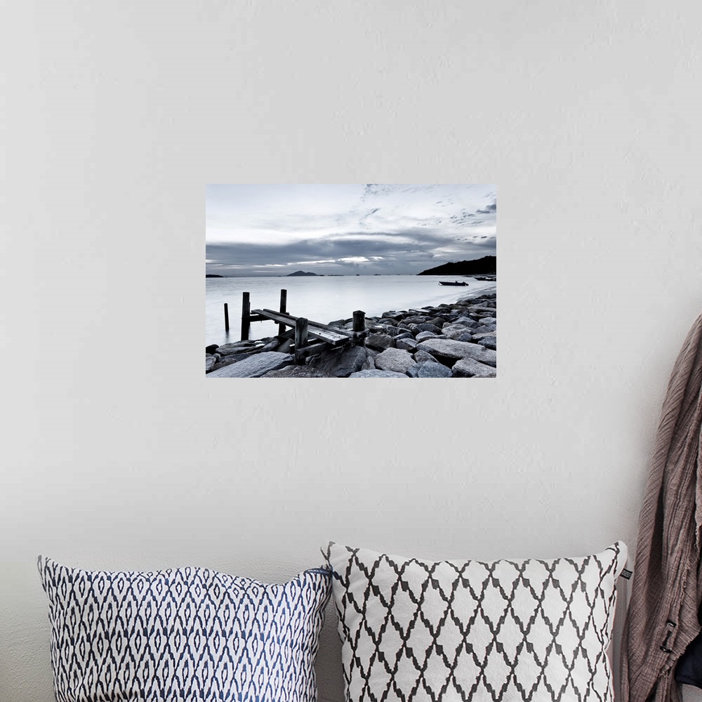 A bohemian room featuring Black and white photography of sky and sea at sunset.