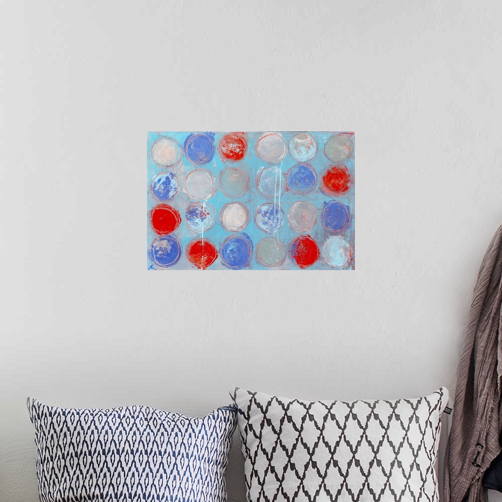 A bohemian room featuring A contemporary abstract painting of colorful circles against a pale blue background.