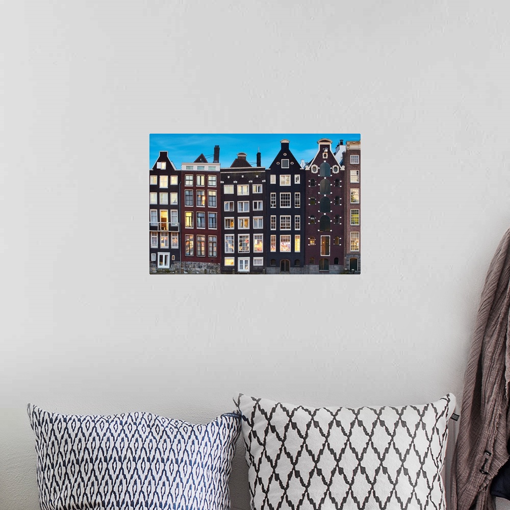 A bohemian room featuring Netherlands, North Holland, Amsterdam, Typical Dutch houses along the Damrak Canal.