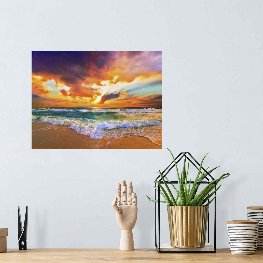 A bohemian room featuring A sandy beach before a bright burning red sunset. Green waves crash onto the sandy sea shore. Lan...