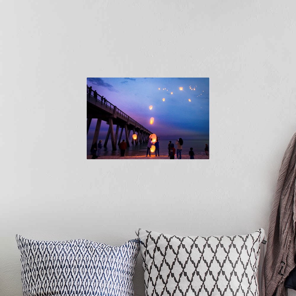 A bohemian room featuring Blue seascape with people releasing paper lanterns over the sea.