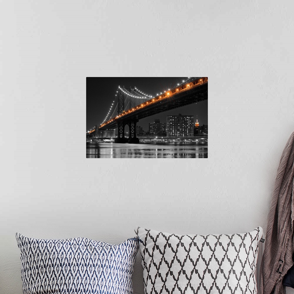 A bohemian room featuring Black and white photograph of the Manhattan Bridge at night with only the lights in color.