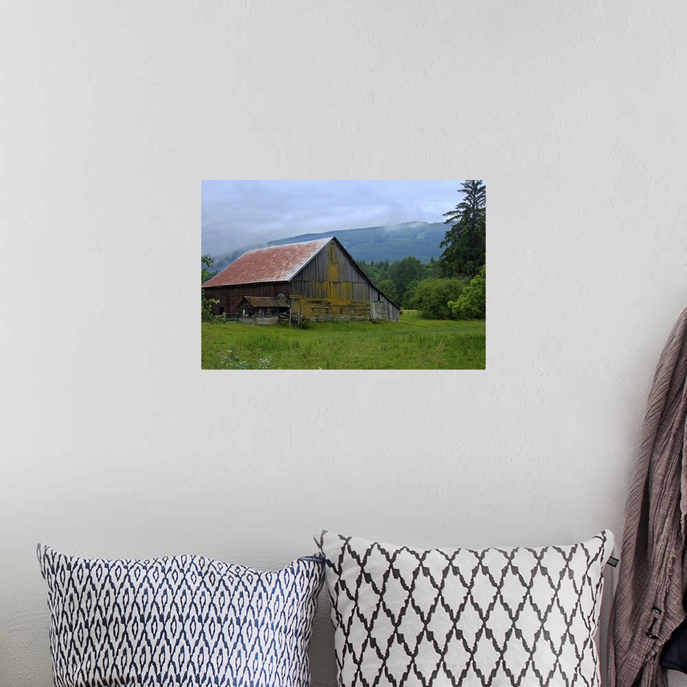 A bohemian room featuring An old wooden barn in a rural field surrounded by fog.