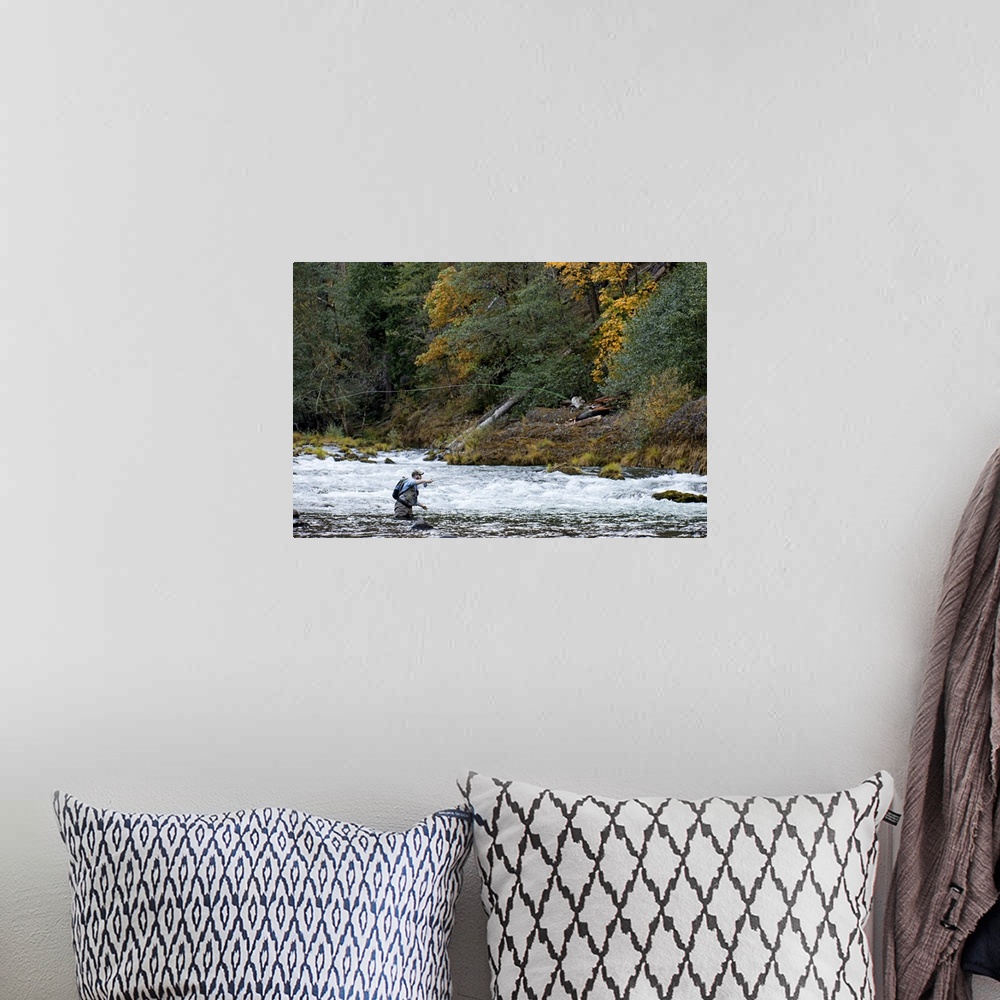A bohemian room featuring A fisherman tries his luck in the rapids of a quick moving river.