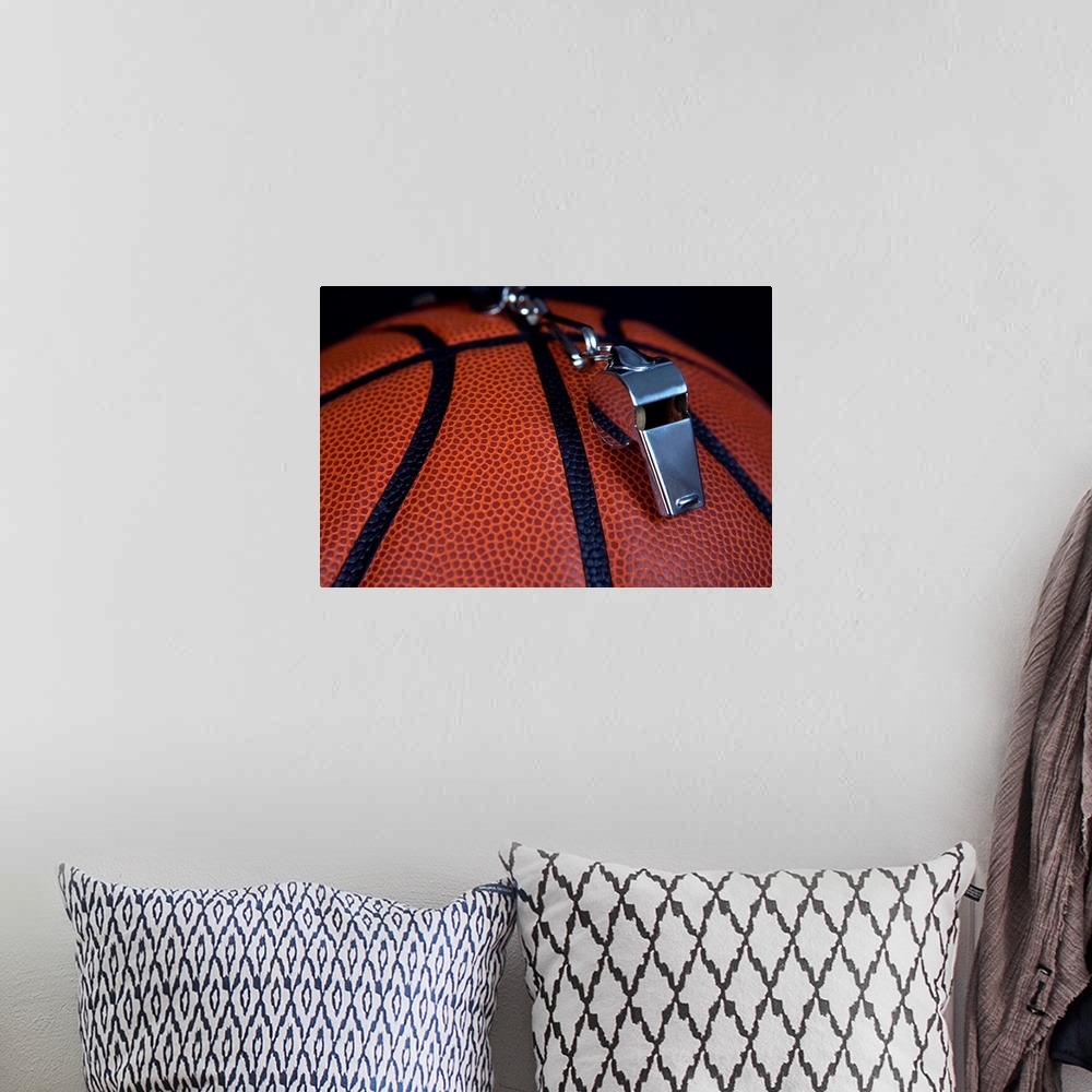 A bohemian room featuring A referee's whistle rests on top of a basketball.  Shot with Canon 5D Mark II.