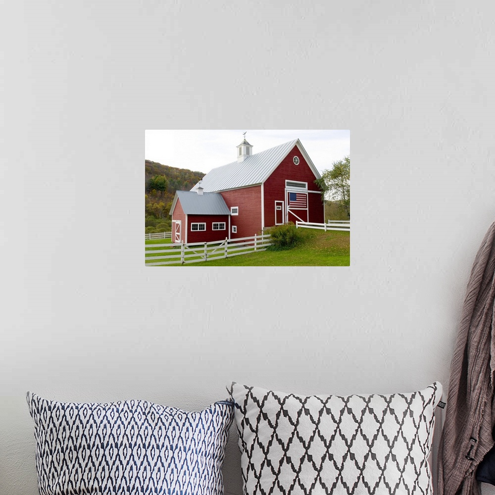 A bohemian room featuring Classic New England farm with red barn and white fence. American flag on barn door. Vermont. USA
