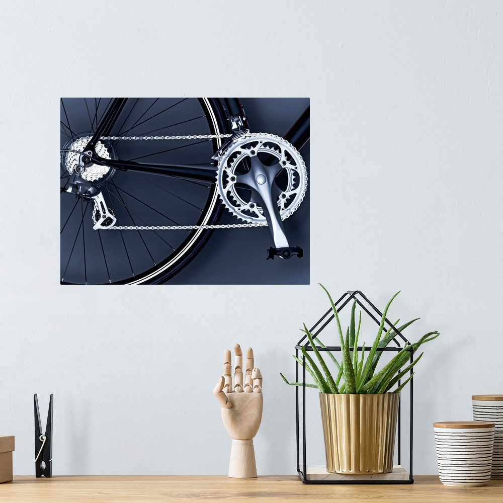 A bohemian room featuring Oversized, horizontal, close up photograph of part of the back wheel, the chain, gears and pedal ...