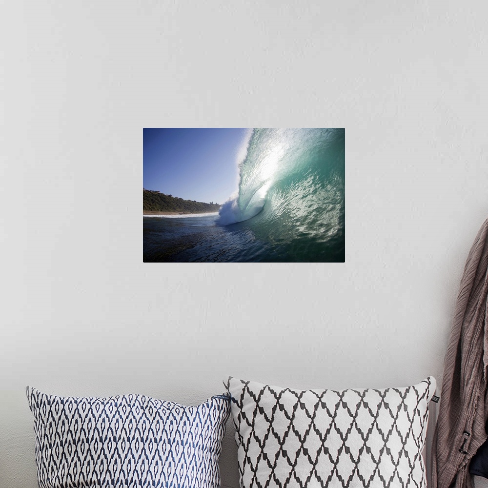 A bohemian room featuring Outdoor photo of a wave curling up and breaking over towards the beach on a sunny day.