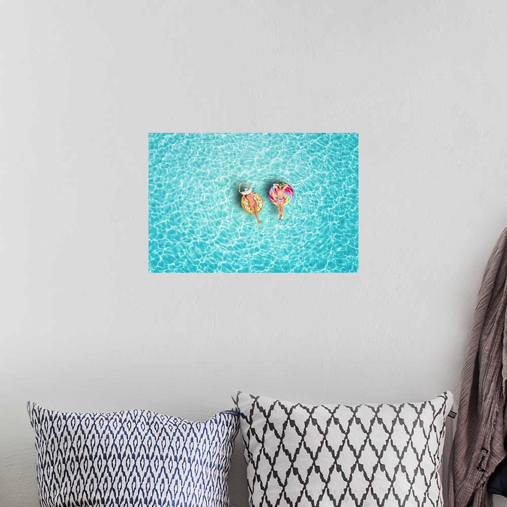A bohemian room featuring A happy vacation couple in swimsuits enjoys the tropical sun of the Maldives on colorful floats o...