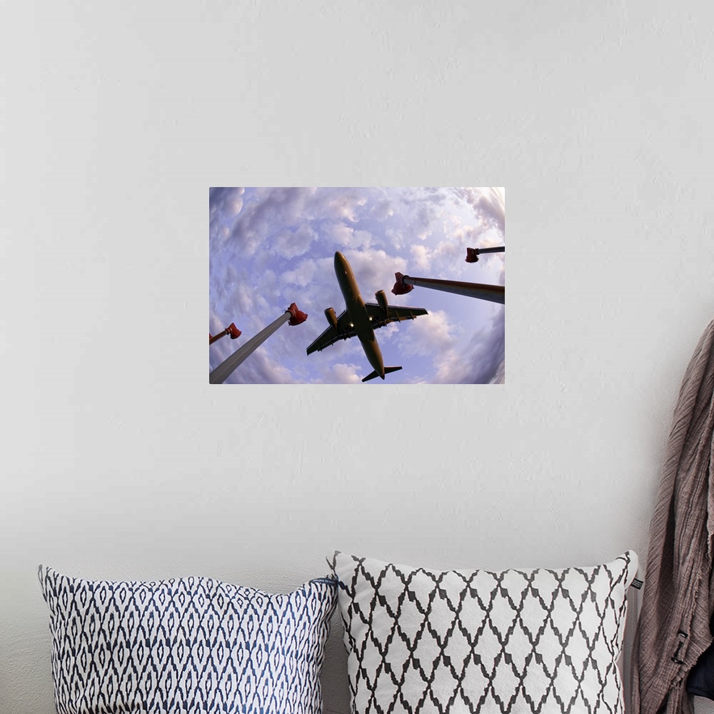 A bohemian room featuring Fisheye wide shot of an airplane landing directly over the viewer