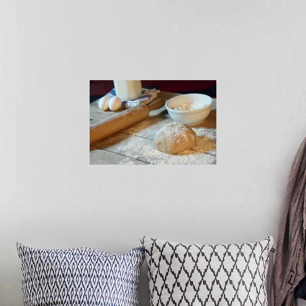 A bohemian room featuring Large horizontal photograph of bread dough in ball on a wooden table, sprinkled with flour.  Obje...