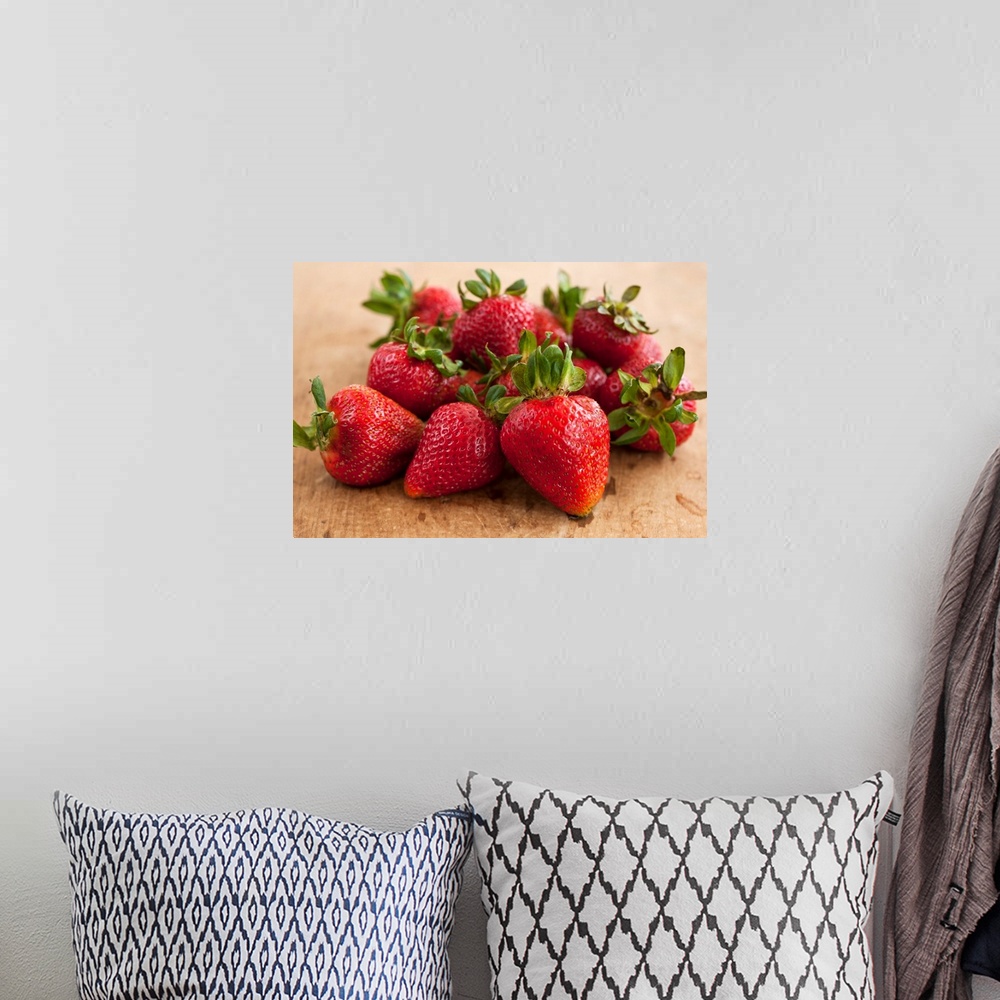 A bohemian room featuring Docor perfect for the kitchen of a batch of strawberries piled together on a wooden surface.