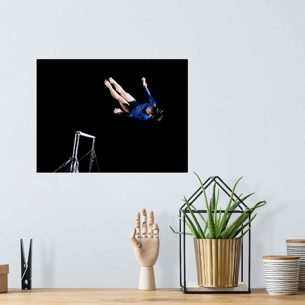 A bohemian room featuring Gymnast (16-17) dismounting uneven bars