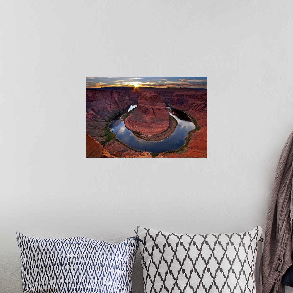 A bohemian room featuring Photograph of river circling huge rock formation at sunset under a cloudy sky.