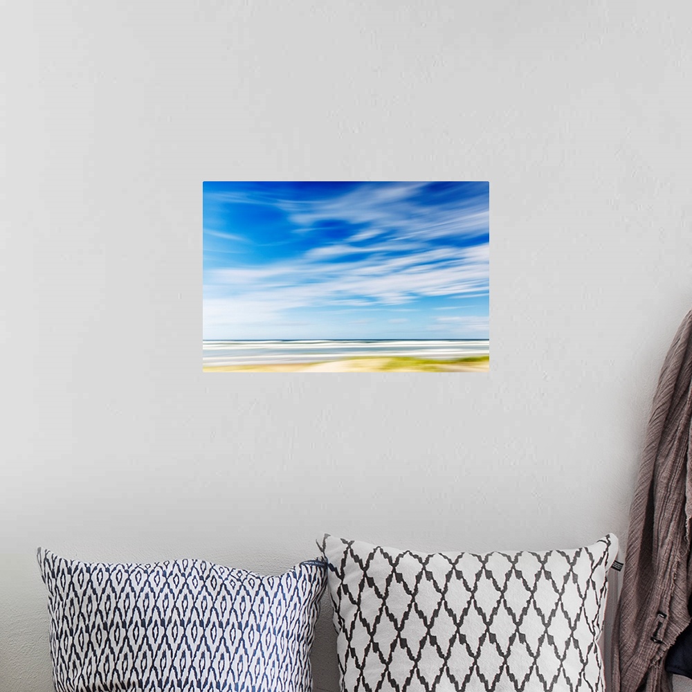 A bohemian room featuring Intentional camera movement of ocean scene of with bright blue sky and wispy clouds. Teewah Beach...