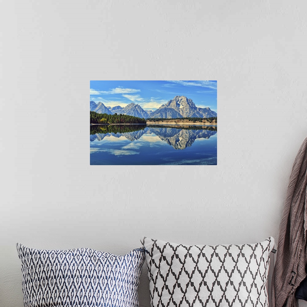 A bohemian room featuring A reflection of Mount Moran and the Teton mountain range in the still waters of Jackson Lake in G...