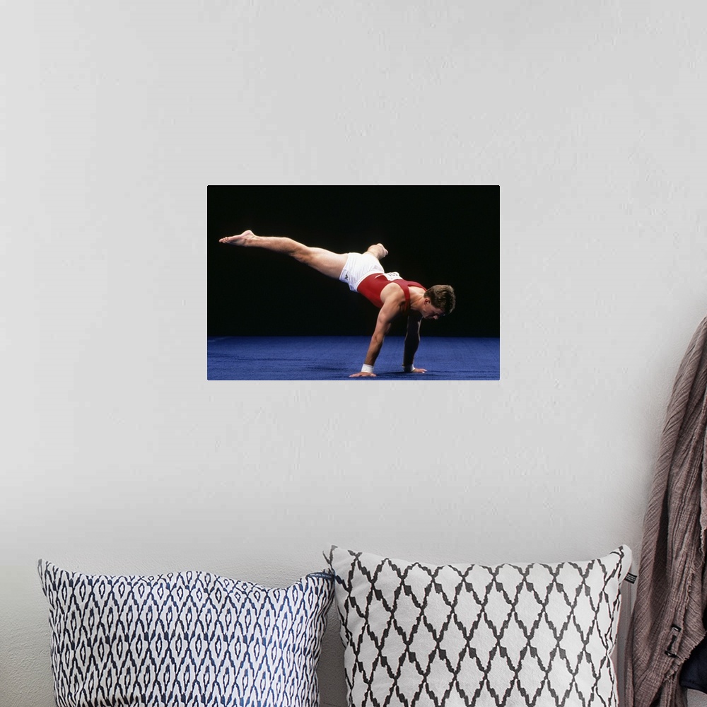 A bohemian room featuring Male gymnast peforming a routine in the floor exercise