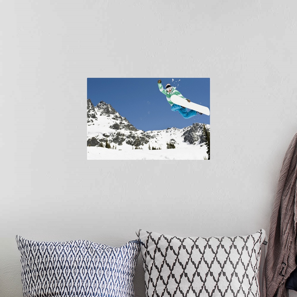 A bohemian room featuring male snowboarder jumping in air