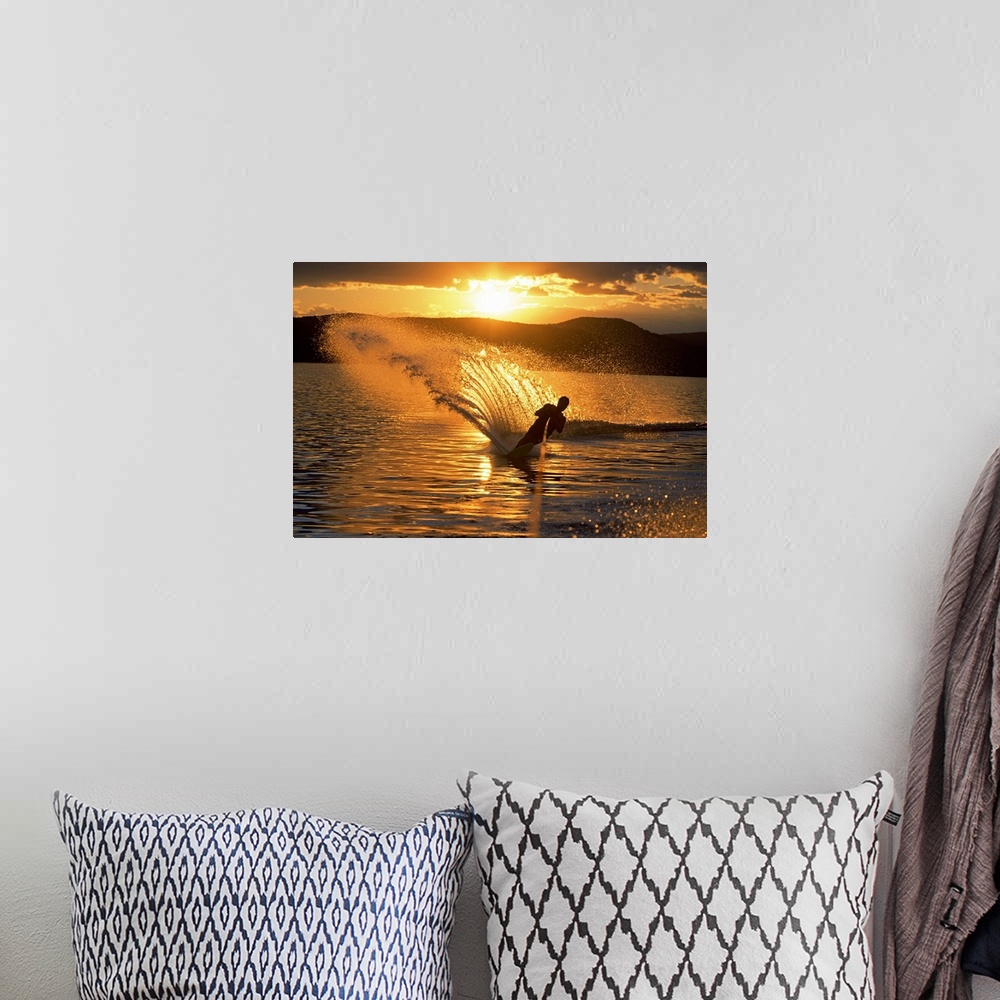 A bohemian room featuring Man waterskiing at dusk