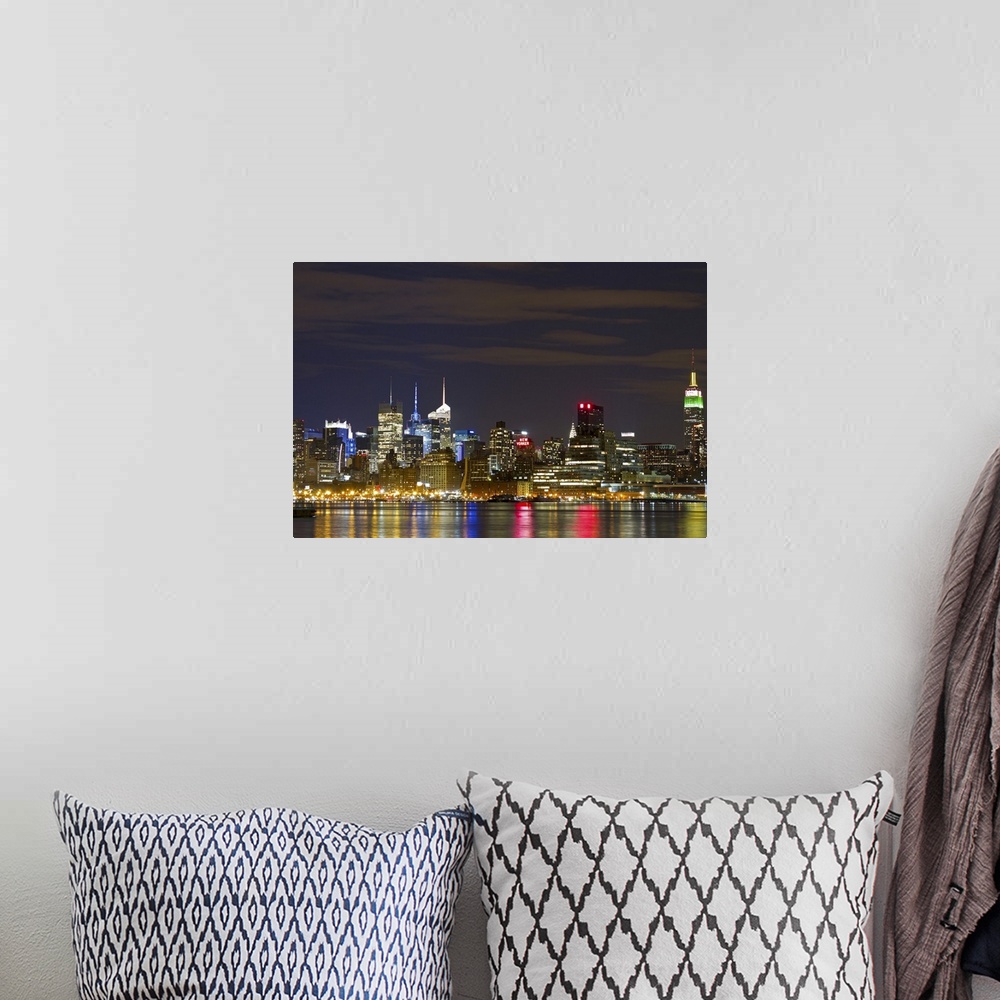A bohemian room featuring Giant landscape photograph of the brightly lit Manhattan skyline at night, reflecting in the water.