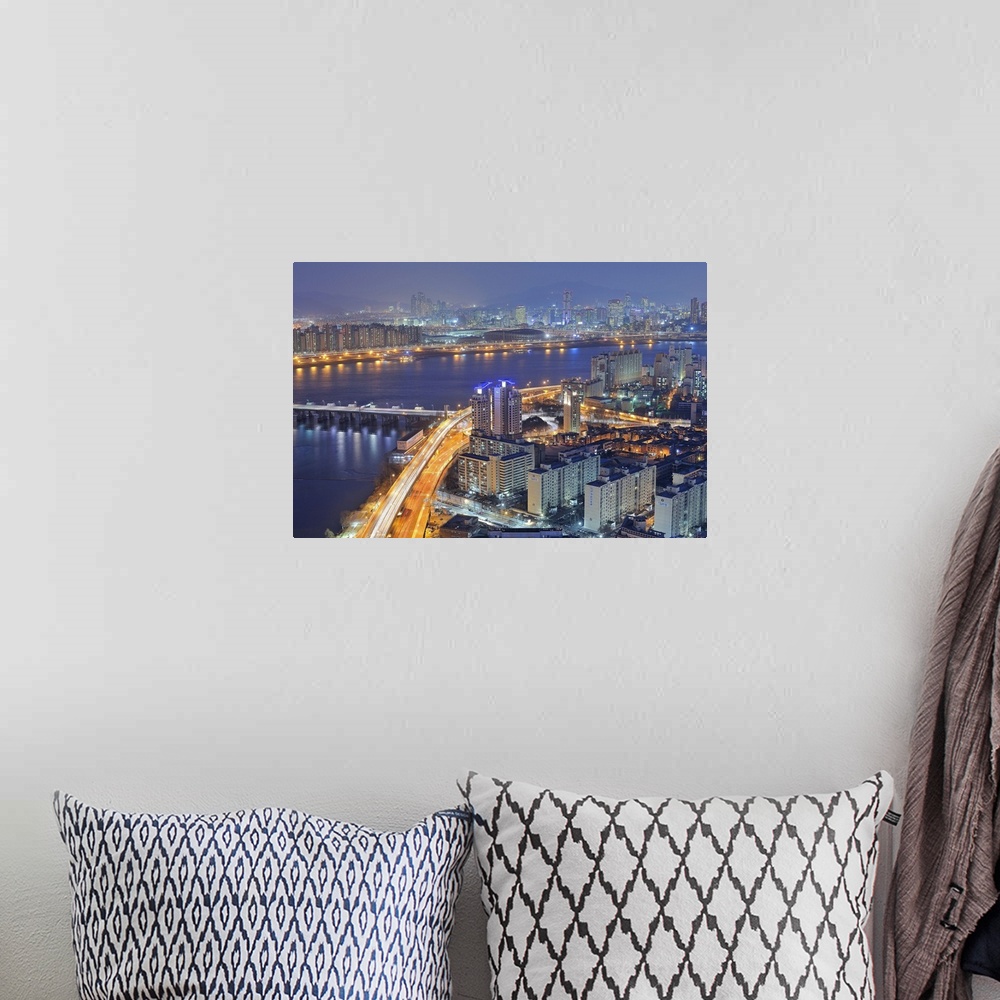 A bohemian room featuring Big canvas photo of a city in Korea lit up at night along the water.