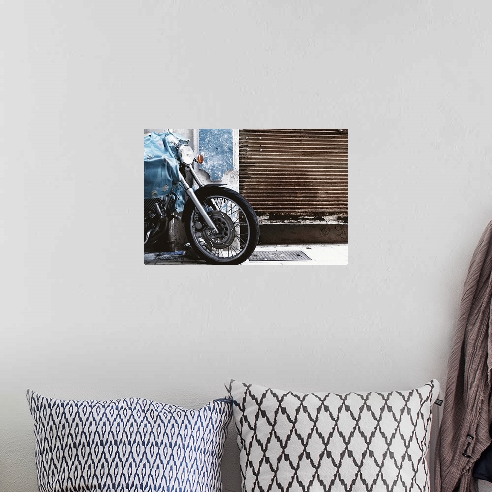 A bohemian room featuring Parked motorcycle with rusty garage door.