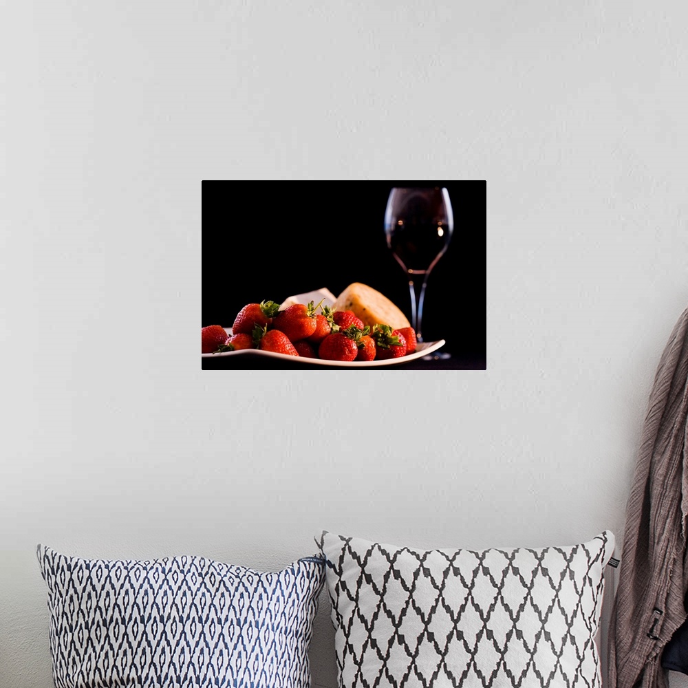 A bohemian room featuring This is a horizontal photograph of fruit, cheeses, and wine against a dark backdrop making this a...
