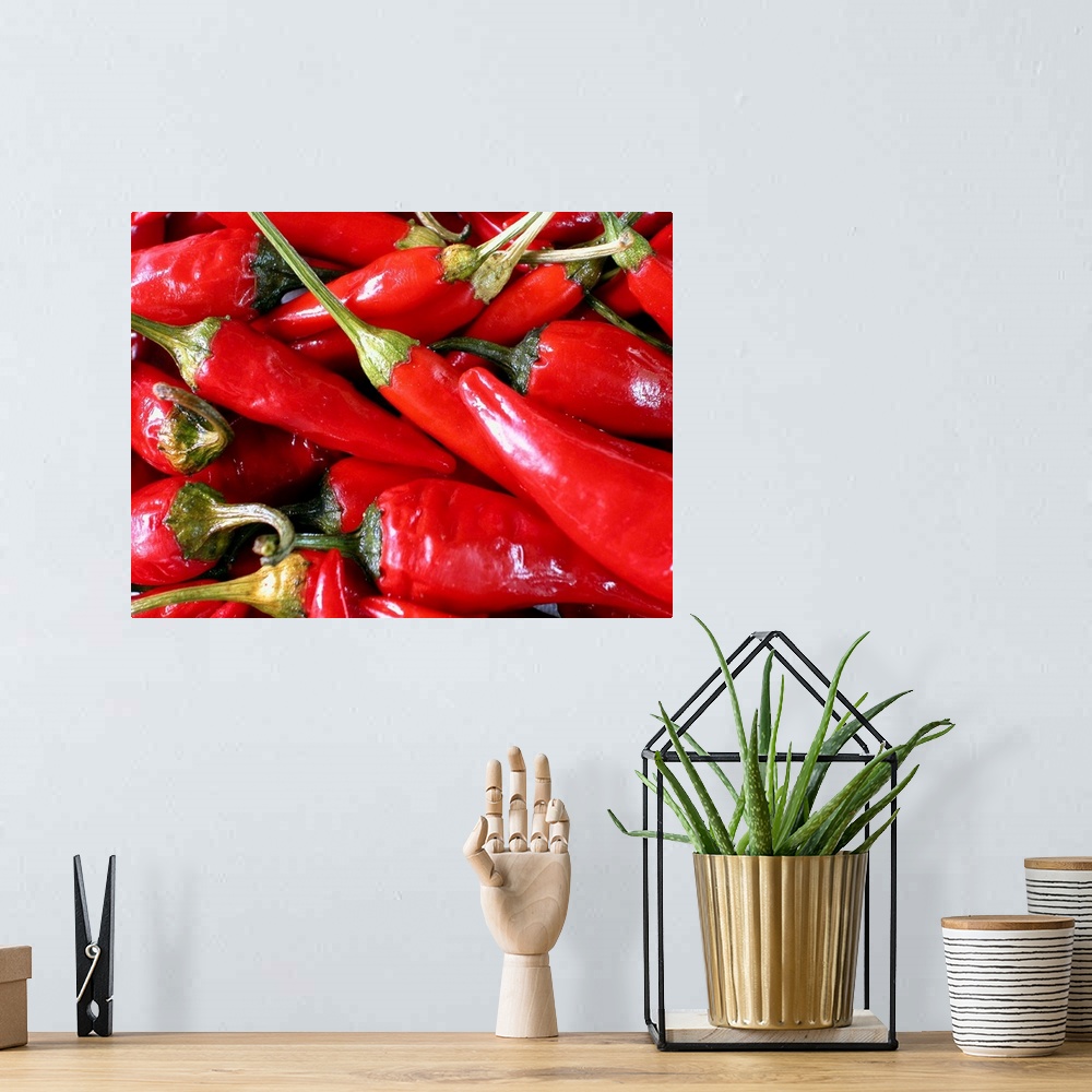 A bohemian room featuring A batch of chili peppers are photographed very closely.