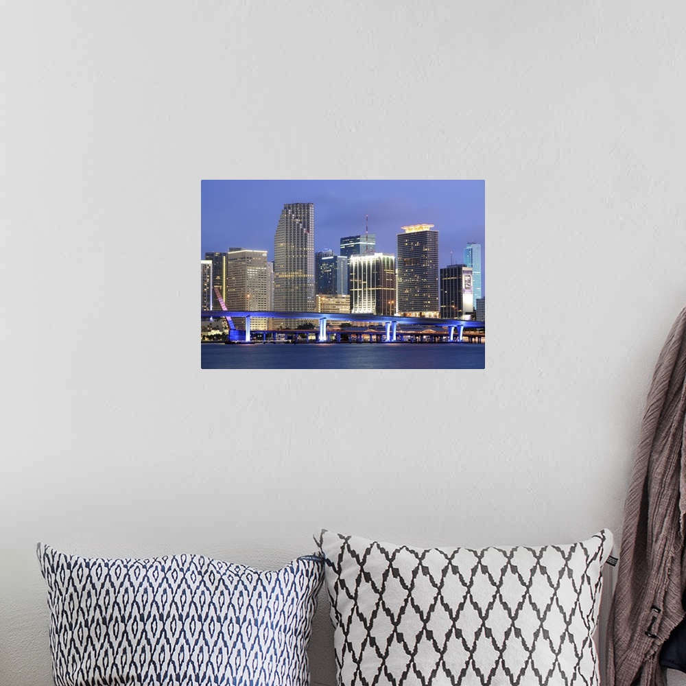 A bohemian room featuring Large canvas photo art of the Miami cityscape lit up at night along the waterfront.
