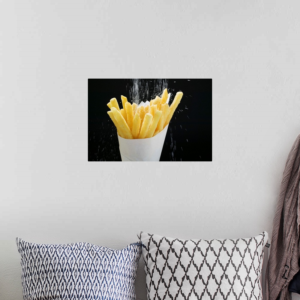 A bohemian room featuring Sprinkling salt on fries in paper cone