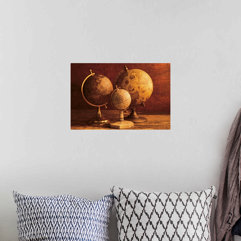 A bohemian room featuring Photograph of three vintage globes of varying sizes sitting on a map table.