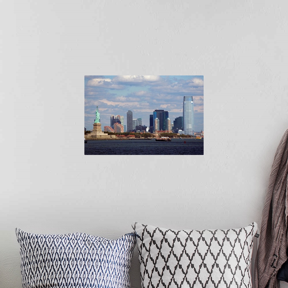 A bohemian room featuring The Statue of Liberty and the NYC skyline are photographed under a cloudy sky.