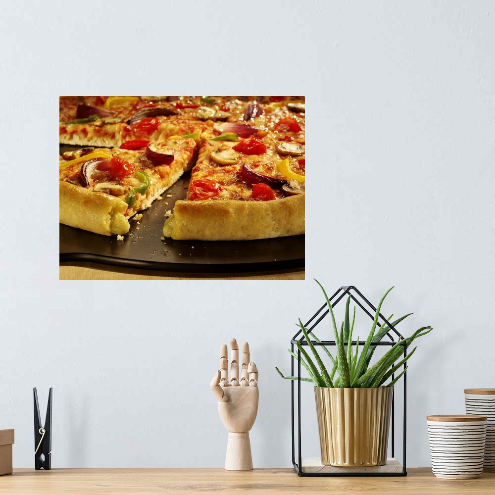 A bohemian room featuring Vegetable pizza sliced on black pan on wood