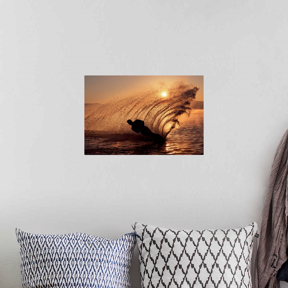 A bohemian room featuring Water-skier at sunset sending up spray of water