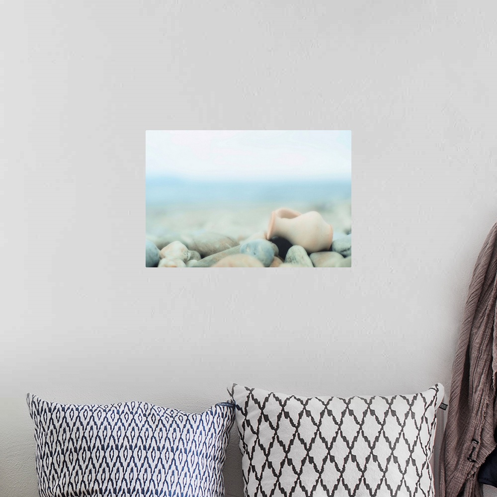 A bohemian room featuring Zen composition on pebble beach, small amphora on  lies pebbles.