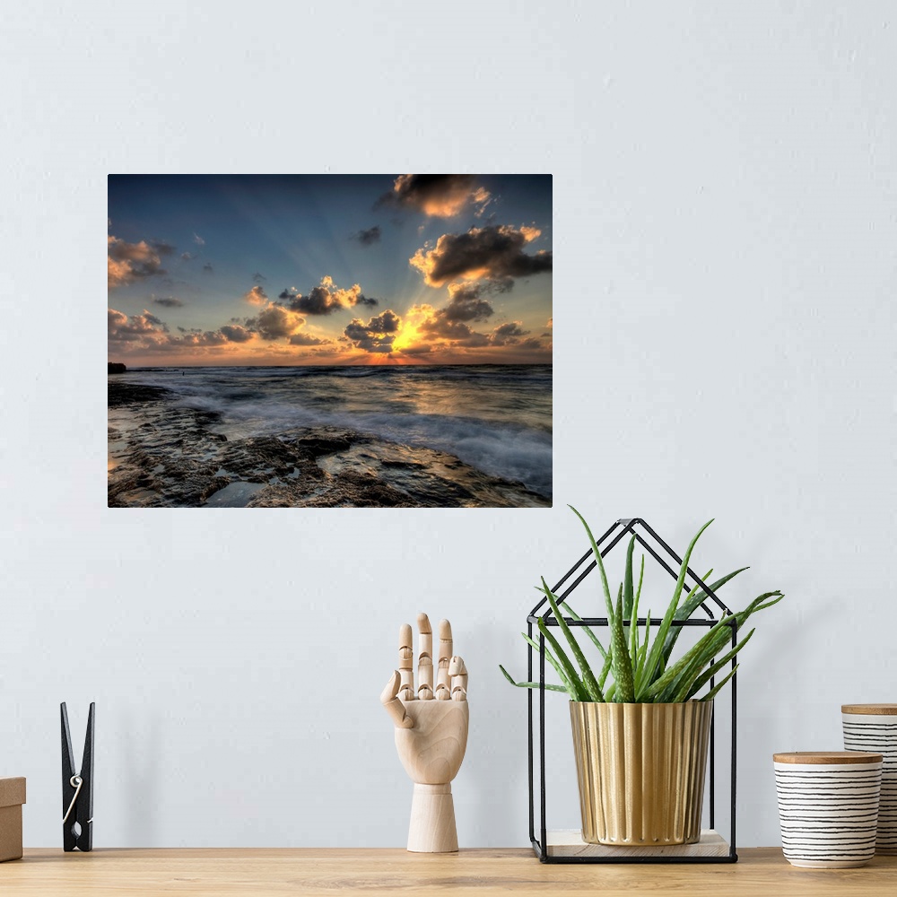 A bohemian room featuring Horizontal photograph of a vibrant, golden sunset at a rocky beach.