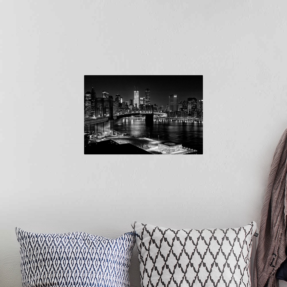 A bohemian room featuring Black and white photograph of a city skyline at night. With abridge spanning over bay.